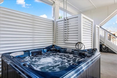Private outdoor hot tub with louvered privacy panels on covered deck at Texas vacation rental