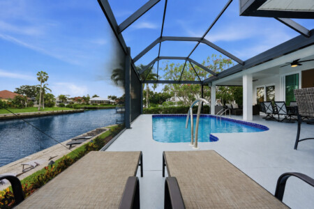 Screened waterfront pool with canal views and relaxing lounge seating at Tigertail Beach Villa, Marco Island FL