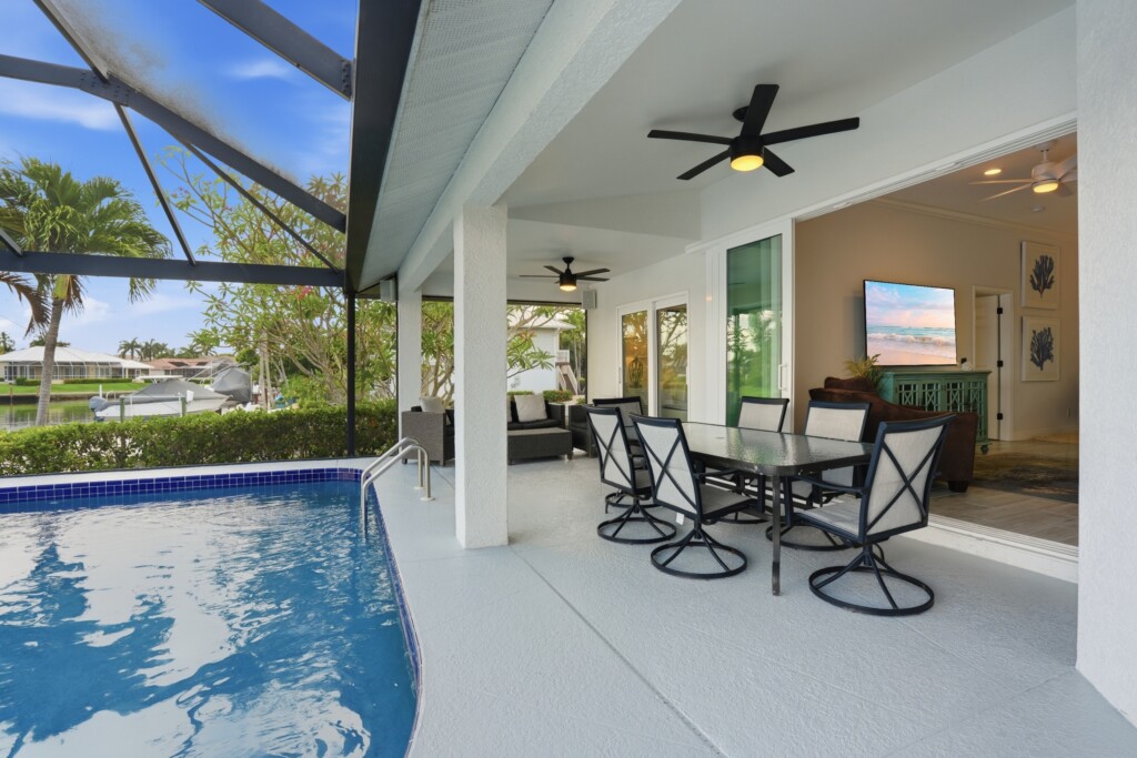 Screened private pool with covered lanai dining and relaxing canal views at Tigertail Beach Villa, Marco Island FL
