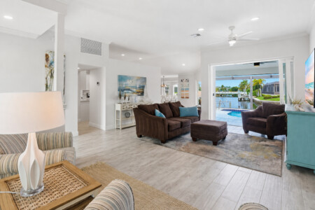 Bright waterfront living room with pool views and easy indoor-outdoor access at Tigertail Beach Villa, Marco Island FL