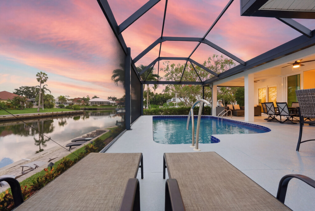 Screened waterfront pool oasis with sunset views and relaxing lounge space at Tigertail Beach Villa, Marco Island FL