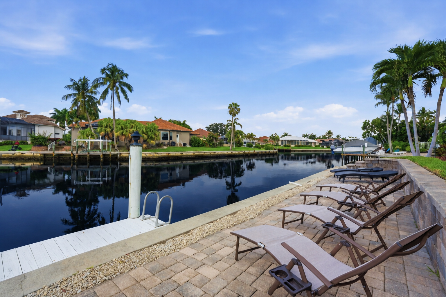 Relax on the waterfront patio with loungers, dock access, and canal views at Tigertail Beach Villa, Marco Island FL