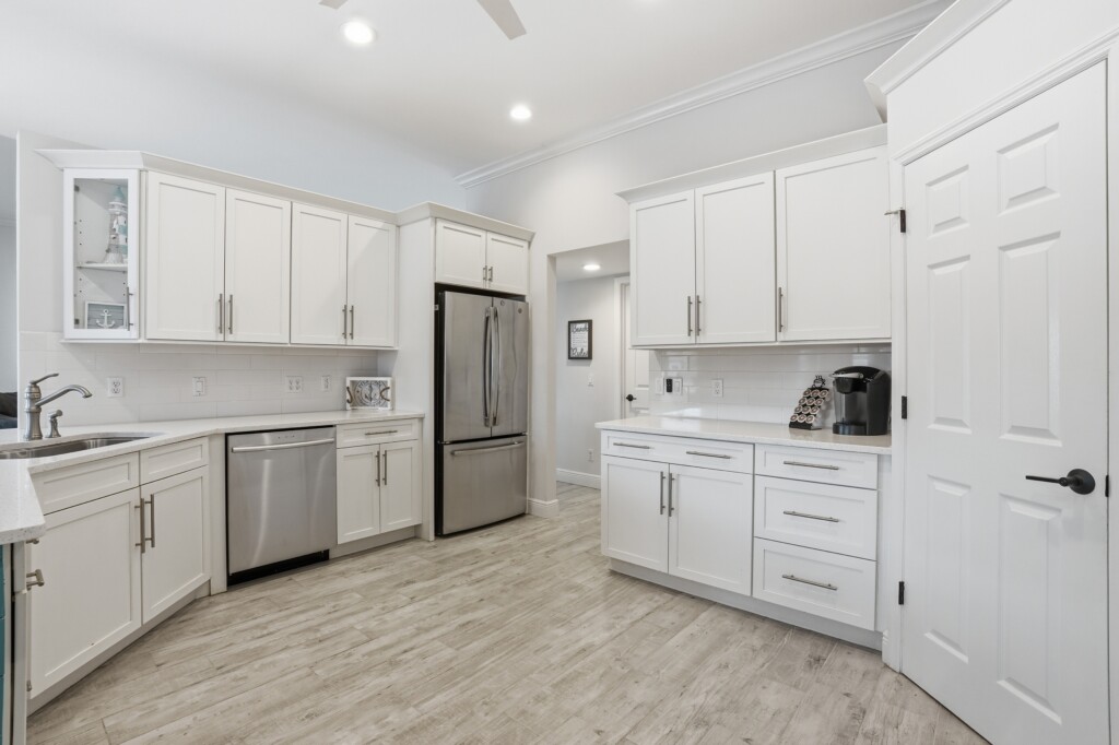 Bright modern kitchen with white cabinets and stainless steel appliances at Tigertail Beach Villa, Marco Island FL