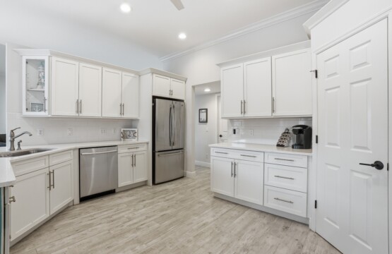 Bright modern kitchen with white cabinets and stainless steel appliances at Tigertail Beach Villa, Marco Island FL