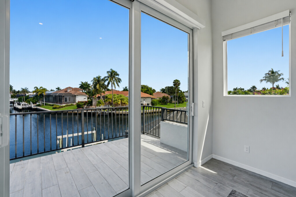 Private balcony with sunny waterfront views and tropical canal scenery at Tigertail Beach Villa, Marco Island FL