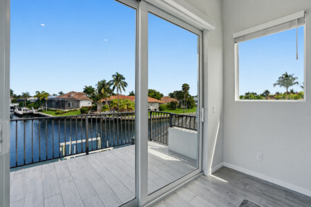 Private balcony with sunny waterfront views and tropical canal scenery at Tigertail Beach Villa, Marco Island FL