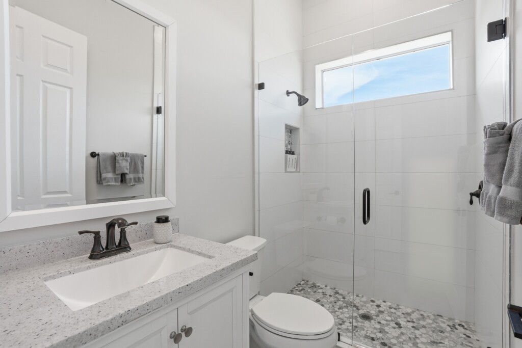 Bright modern bathroom with walk-in glass shower and stylish finishes at Tigertail Beach Villa, Marco Island FL