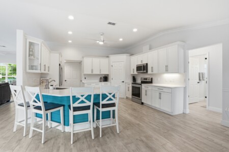 Bright open kitchen with stylish island seating and modern finishes at Tigertail Beach Villa, Marco Island FL