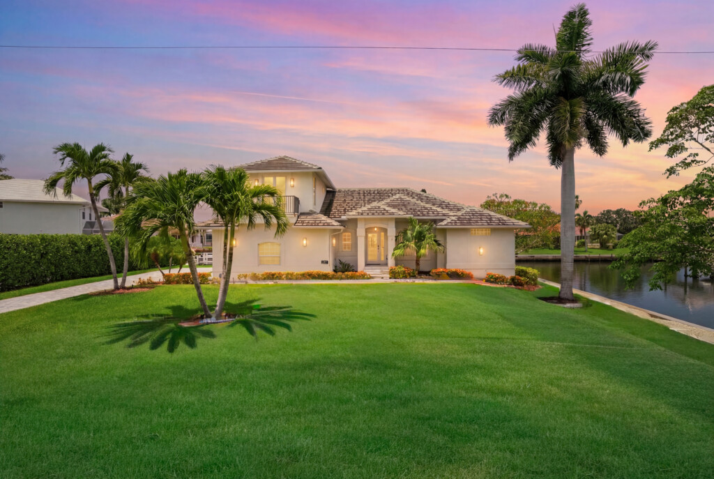 Tropical waterfront home with lush lawn and stunning sunset views at Tigertail Beach Villa, Marco Island FL