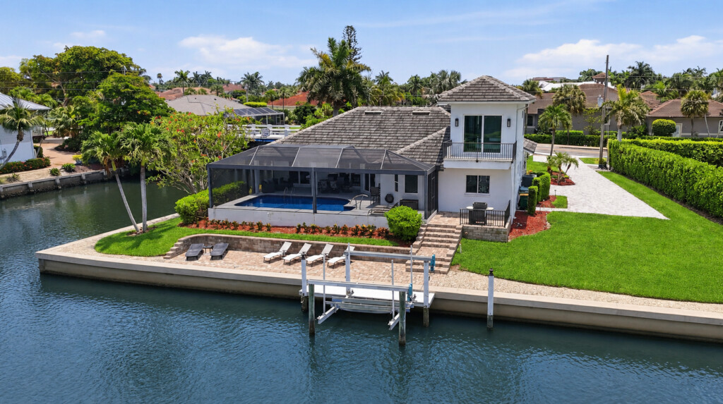 Waterfront retreat with private dock, screened pool, and lush outdoor space at Tigertail Beach Villa, Marco Island FL