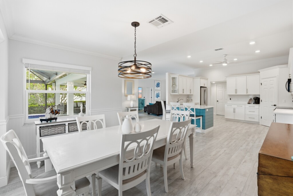 Bright open kitchen and dining space with stylish island and natural light at Tigertail Beach Villa, Marco Island FL