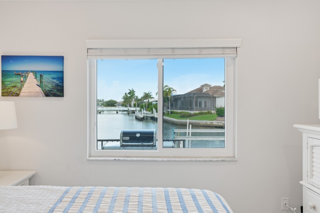 Bright coastal bedroom with peaceful waterfront canal views at Tigertail Beach Villa, Marco Island FL