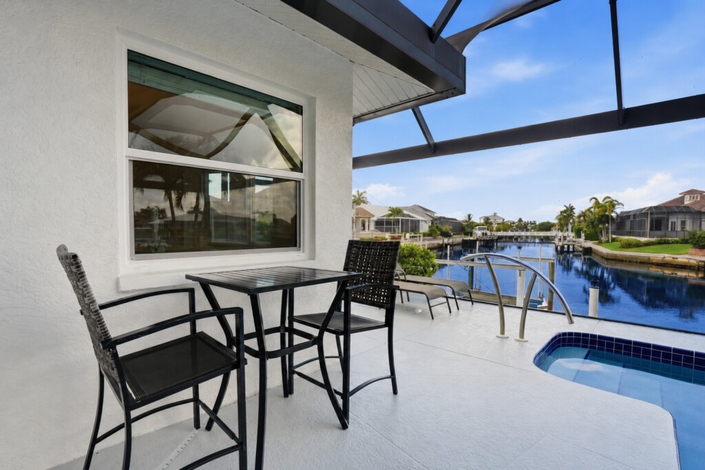 Covered waterfront patio with canal views and private pool access at Tigertail Beach Villa, Marco Island FL
