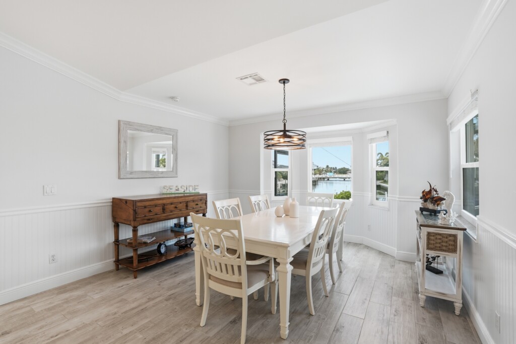 Bright coastal dining room with seating for 6 and lovely water views at Tigertail Beach Villa, Marco Island FL