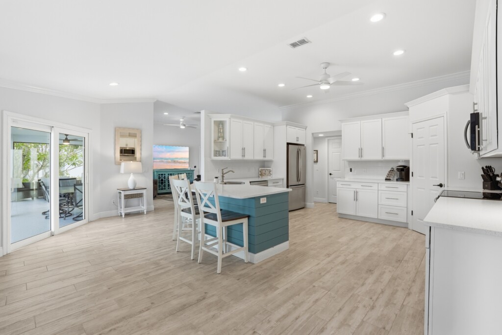 Bright modern kitchen with island seating and easy patio access at Tigertail Beach Villa, Marco Island FL